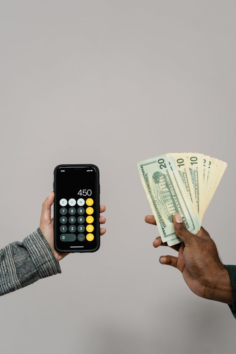 hands holding a calculator and cash money